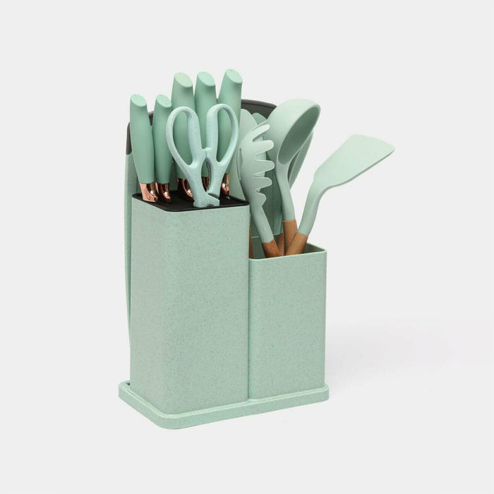 18-piece silicone kitchenware set in a holder including spatulas, ladle, tongs, whisk, pasta server, brushes, and scissors, neatly organized on a kitchen countertop.