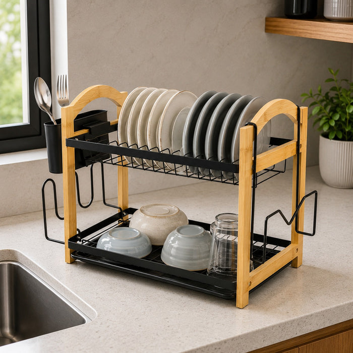 2 Tier Kitchen Dish Drying Rack on a kitchen countertop, holding plates, bowls, and a glass jar. The background shows a kitchen sink, window, and shelf.