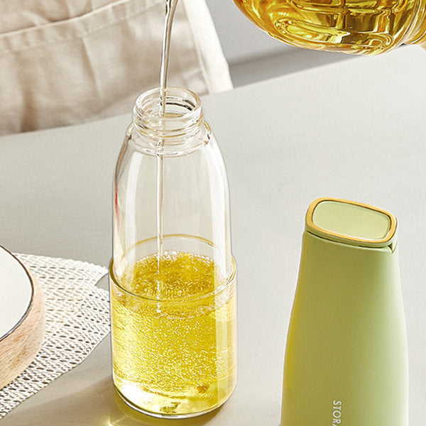 Someone is pouring oil into a 500ml Automatic Opening and Closing Kitchen Oil Bottle