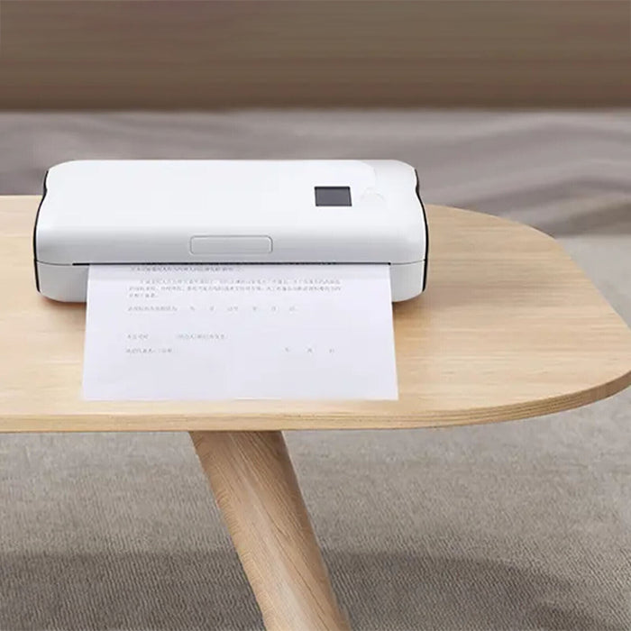 A A4 Portable Thermal Printer sitting on a light wood table, with a sheet of printed labels emerging from the front.