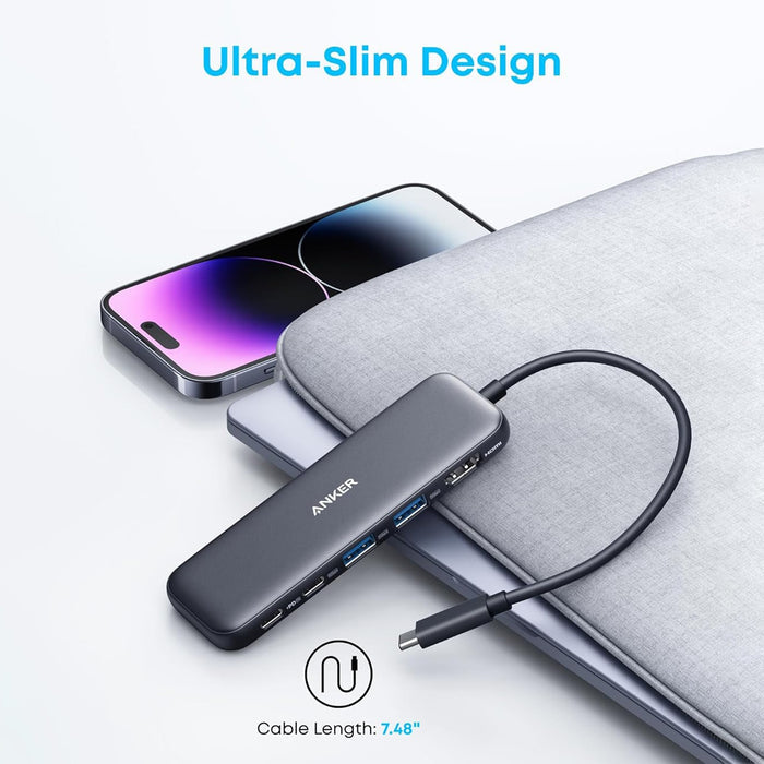 An Anker ultra-slim USB-C hub connected to a laptop, showcasing its compact design with multiple ports and a short built-in cable for convenient portable connectivity.