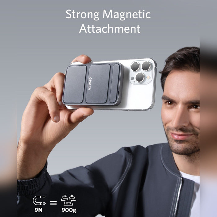 A man is holding a mobile phone connected to a 5000 mAh Wireless Portable Charger