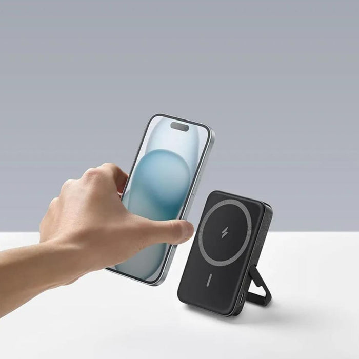 A Person is Placing Mobile Phone On  Anker MagGo 322 Power Bank.