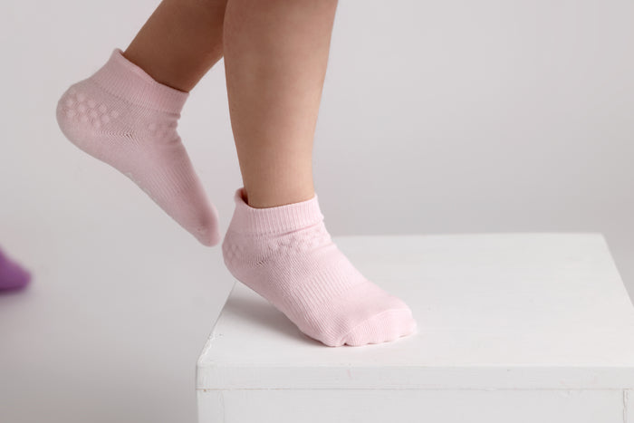 Ciara ankle socks: child standing on tiptoe in powder pink ankle socks. Squid Socks, the brand seen on Shark Tank.