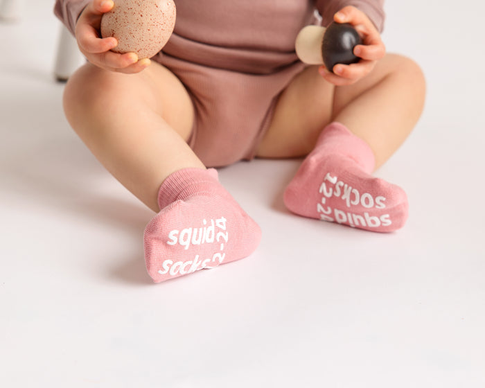 Ciara ankle socks: baby seated showing rose sock soles. Squid Socks, the brand seen on Shark Tank.