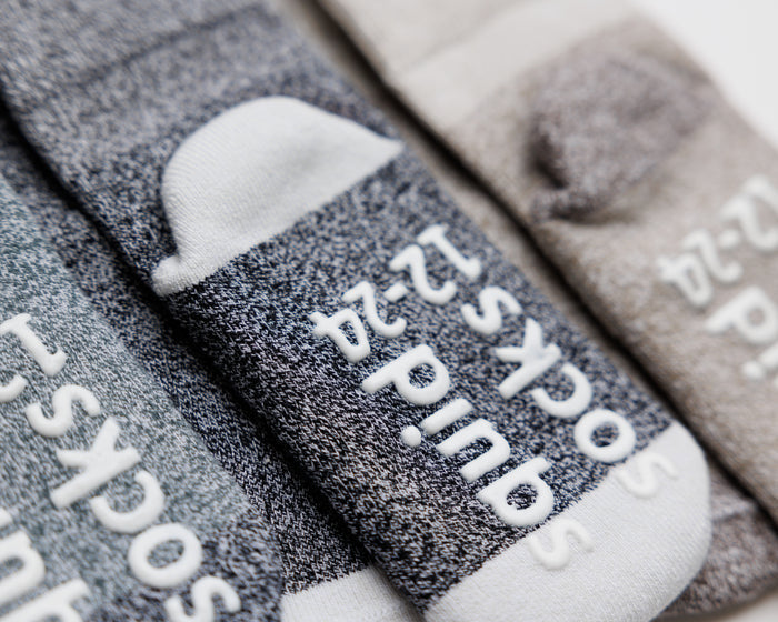 Caelan cotton crew socks: close-up of gray crew socks showing contrasting heels and sole grips. Squid Socks, the brand seen on Shark Tank.