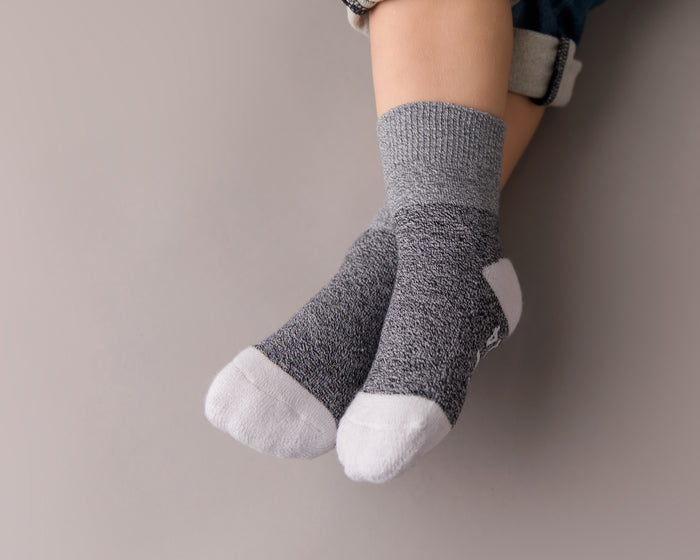 Caelan cotton crew socks: child wearing dark gray crew socks with white toes. Squid Socks, the brand seen on Shark Tank.