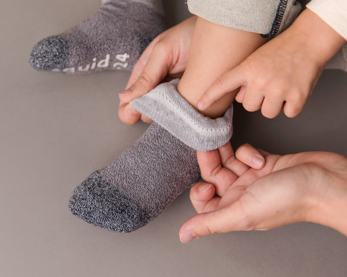 Caelan cotton crew socks: adult folding down a gray sock cuff on a child. Squid Socks, the brand seen on Shark Tank.
