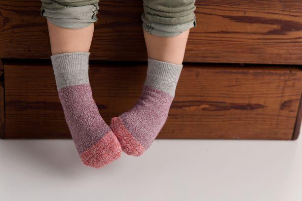 Chris cotton crew socks: child wearing gray-cuff socks on a wooden box. Squid Socks, the brand seen on Shark Tank.