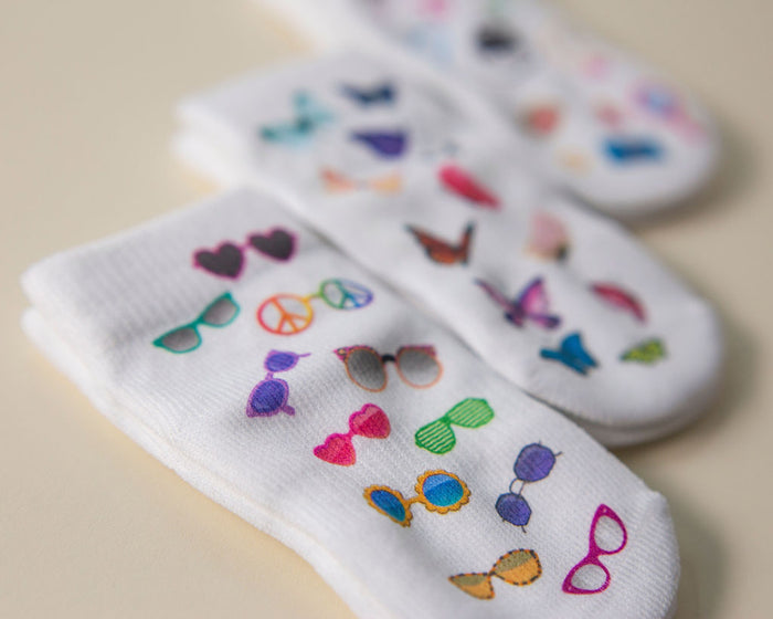 Caitlyn kids socks: sunglasses-print socks arranged with other colorful designs. Squid Socks, the brand seen on Shark Tank.