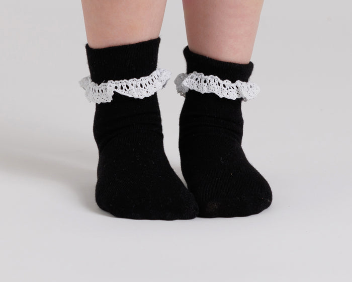 Candace kids socks: child standing in black lace-trim socks. Squid Socks, the brand seen on Shark Tank.