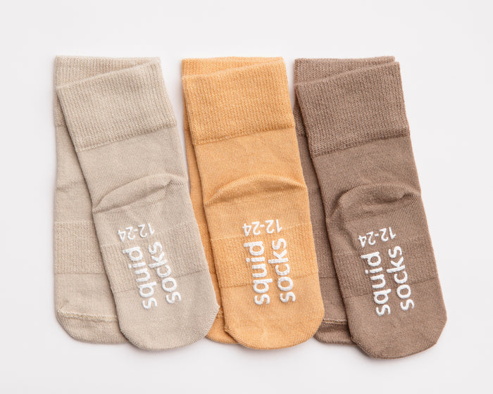 Caramel kids socks: three warm neutral socks showing branded soles. Squid Socks, the brand seen on Shark Tank.