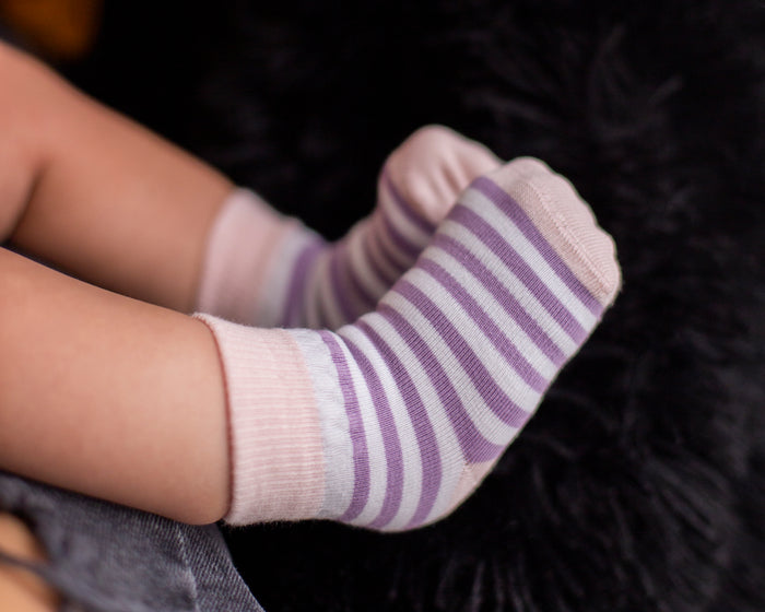 Caroline kids socks: close-up of a child wearing purple striped socks. Squid Socks, the brand seen on Shark Tank.