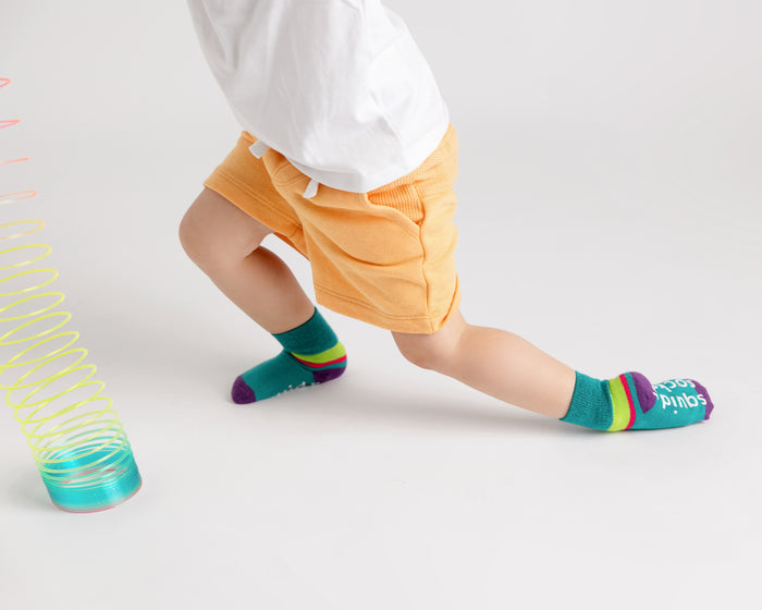 CeCe kids socks: child playing in teal color-block socks. Squid Socks, the brand seen on Shark Tank.