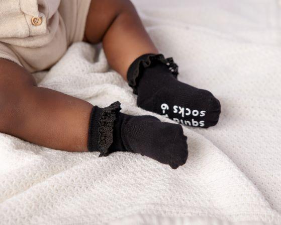 Charlotte kids socks: baby wearing black lace-trim socks. Squid Socks, the brand seen on Shark Tank.
