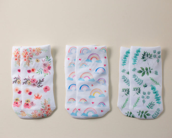 Chloe kids socks: three socks laid flat with floral, rainbow and foliage prints. Squid Socks, the brand seen on Shark Tank.