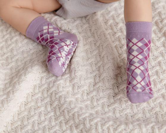 Christina kids socks: baby wearing lavender argyle socks on a blanket. Squid Socks, the brand seen on Shark Tank.