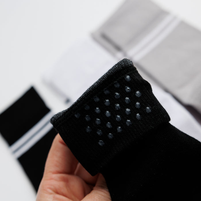 City kids socks: hand holding a black cuff to show silicone dots. Squid Socks, the brand seen on Shark Tank.