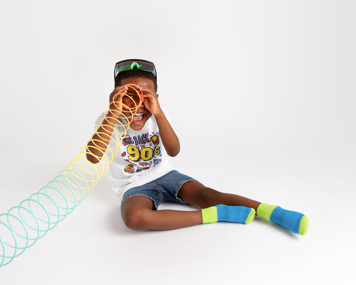 Clint kids socks: child playing with a spring toy in blue socks. Squid Socks, the brand seen on Shark Tank.