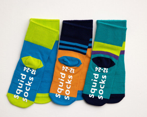 Clint kids socks: three colorful socks showing branded sole grips. Squid Socks, the brand seen on Shark Tank.