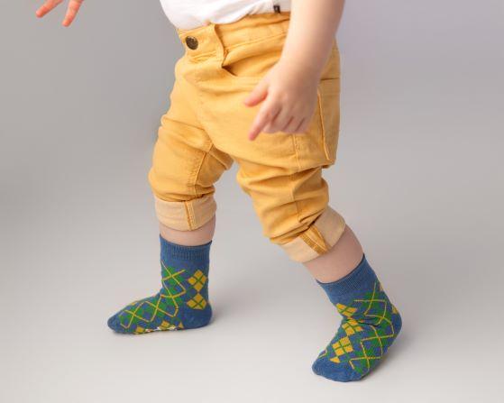 Colin kids socks: child standing in blue argyle socks. Squid Socks, the brand seen on Shark Tank.