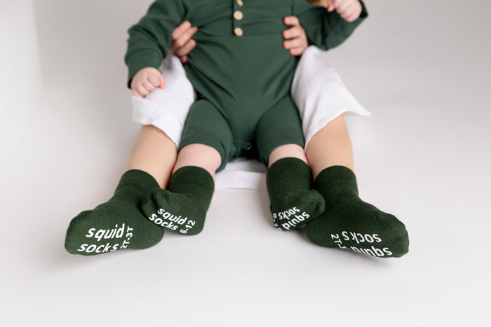 Cypress kids socks: children wearing dark green socks with branded soles. Squid Socks, the brand seen on Shark Tank.
