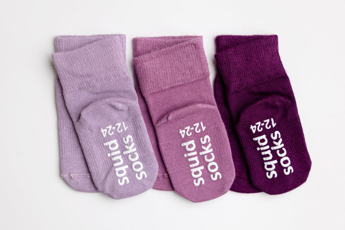 Orchid kids socks: three purple-toned socks showing branded sole grips. Squid Socks, the brand seen on Shark Tank.