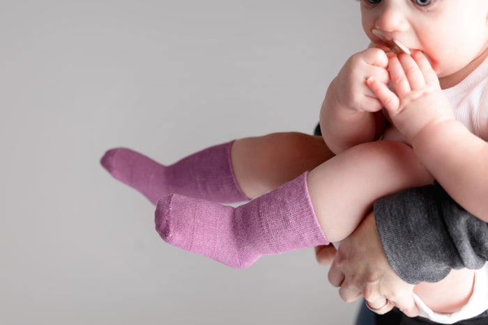 Orchid kids socks: adult holding a baby wearing bright lavender socks. Squid Socks, the brand seen on Shark Tank.