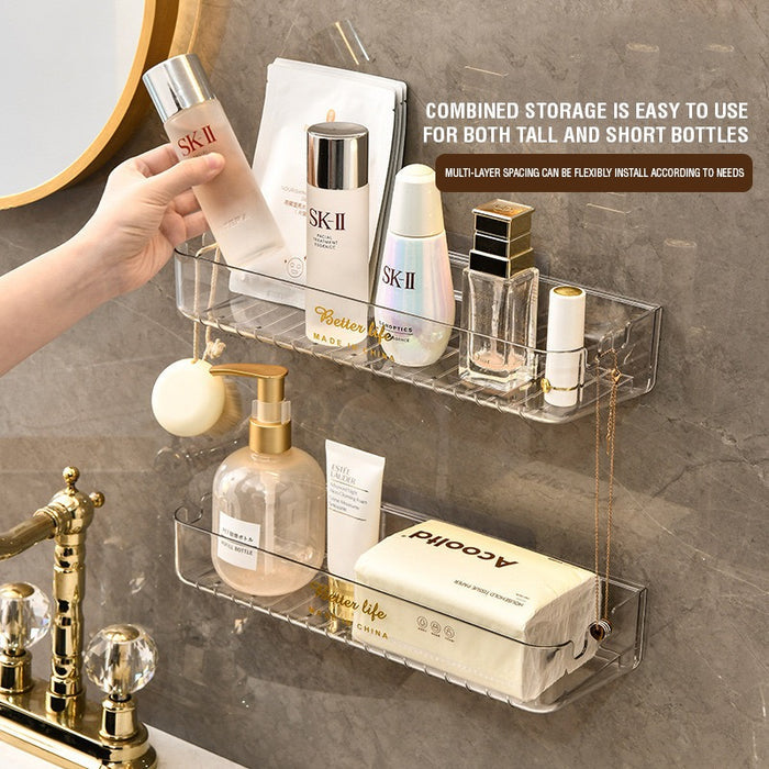 A transparent plastic shelf designed for bathroom storage, featuring a gold necklace and perfume bottle, perfect for organizing toiletries and cosmetics