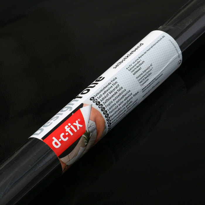 A d-c-fix black glossy adhesive vinyl rolls on a black glossy background.