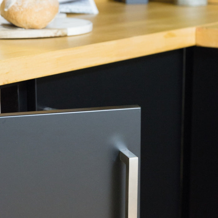 A close up of a black matte adhesive vinyl wrapped kitchen with a cupboard door slightly open.