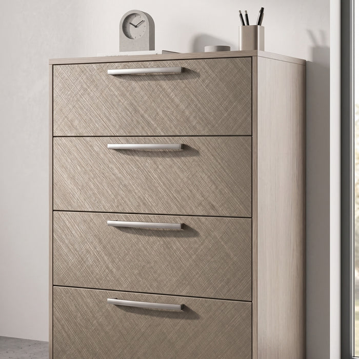 Brushed Linen Brass Metallic adhesive vinyl wrapped dresser with four drawers and decorative items on top against a light background