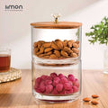 A Two Layer Candy Jar with Wooden Lid Filled with Nuts.