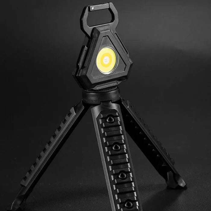 A COB rechargeable keychain pocket light with its stand.