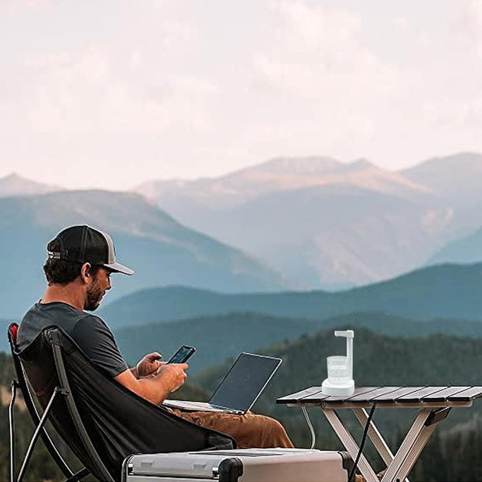 a man working on laptop while traveling with travel friendly water dispenser