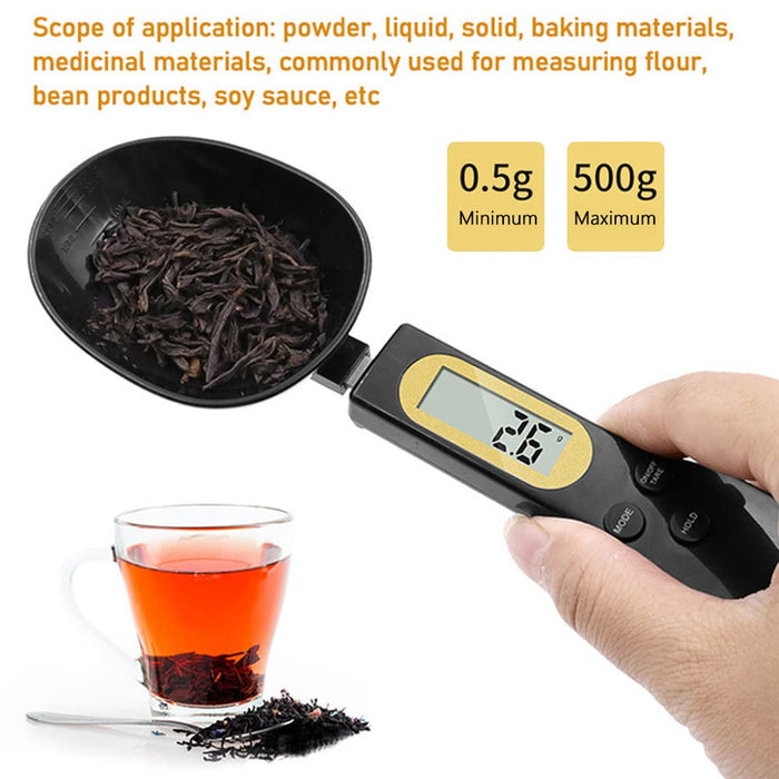 A Person is Holding some food objects on Digital Spoon Scale 500g Kitchen Measuring Spoon and it shows its weight.
