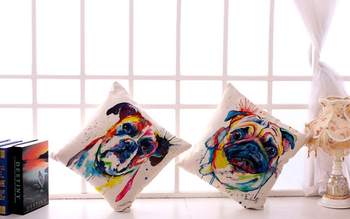 Two colorful pug and  boxer dog -themed pillows on a white surface with a grid-patterned wall in the background.