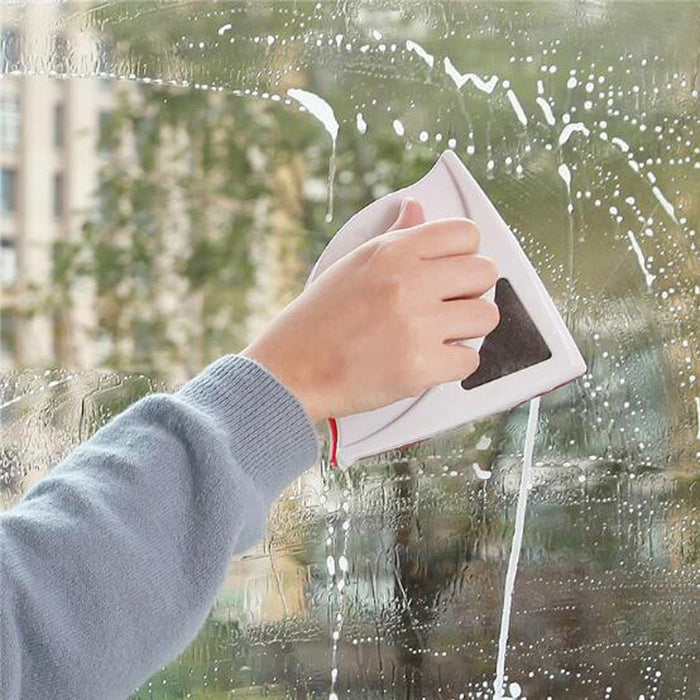 A person cleaning a window with using  magnetic window cleaner