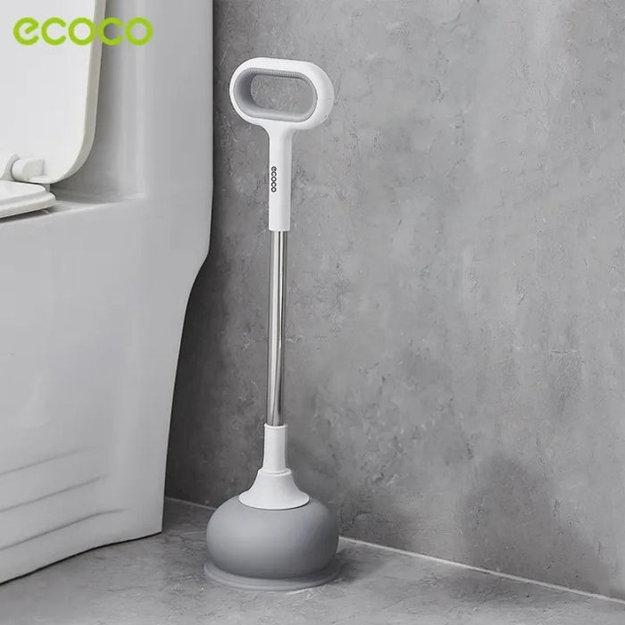 An Ecoco toilet plunger is placed on the bathroom floor beside a toilet.