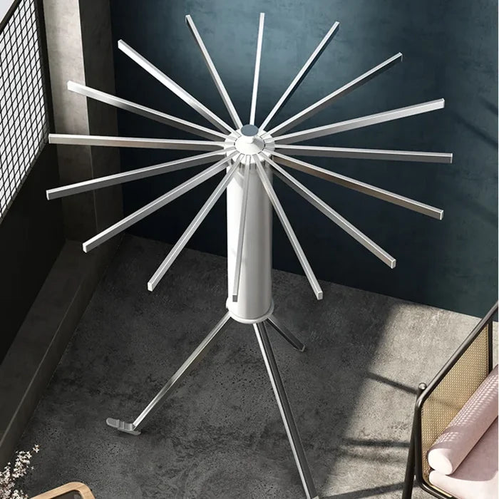 The Foldable Clothes Hanger Airer Umbrella, Installation-Free Laundry Rail with 16 Drying Rods is placed on the floor next to the window