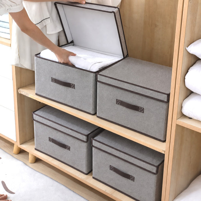 A Person is Keeping Clothes on Foldable Fabric Storage Box with brown handles on a wooden shelf.