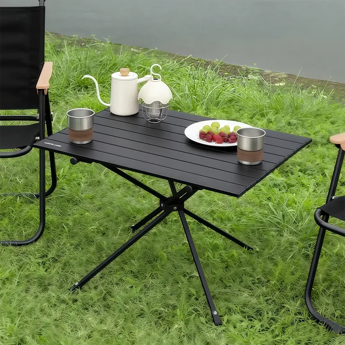 Green Lion Camp T2 Foldable Camping Table with outdoor furniture on a grassy area