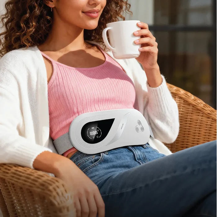 Woman holding a mug with a white Green Lion Rapid Heat Menstrual Heating Pad on her waist, sitting outdoors.