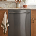 Stainless steel dishwasher in a kitchen with wooden cabinets and marble countertop.