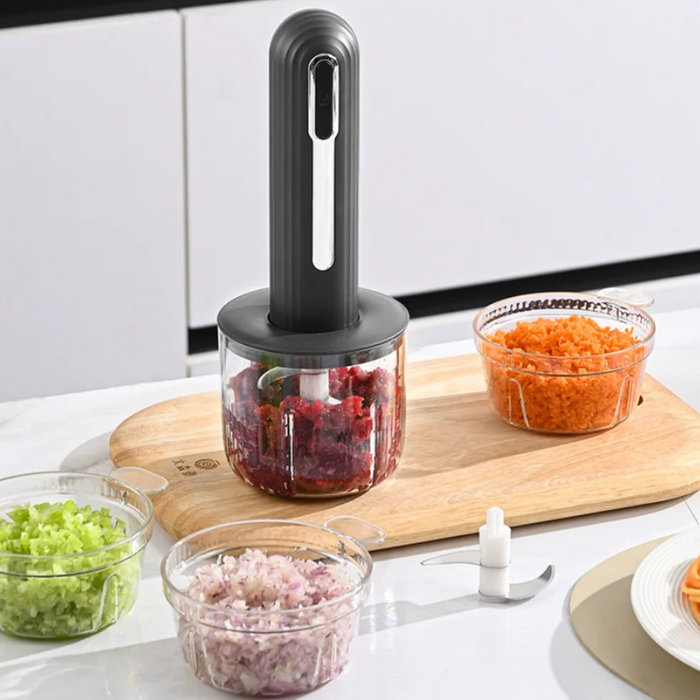USB rechargeable food processor blender shown on a kitchen counter with detachable blades, glass bowls filled with minced meat, chopped mushrooms, and grated carrots.