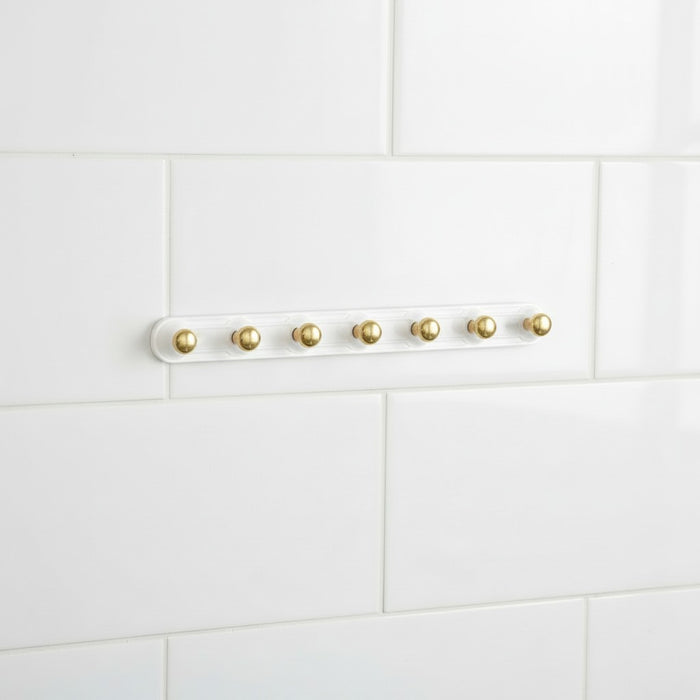 Adhesive Wall Hooks on a white tiled wall background