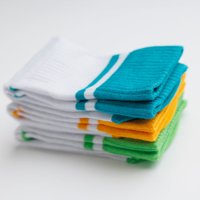 Landyn kids socks: stack of white socks with teal, yellow and green cuffs. Squid Socks, the brand seen on Shark Tank.