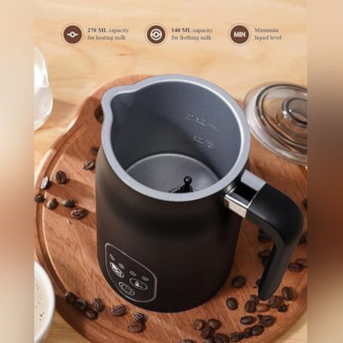 The interior view of a black electric milk frother placed on a wooden serving tray surrounded by scattered coffee beans,