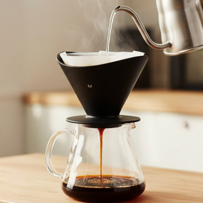 Coffee being brewed into a glass carafe using a Macnoa MacDrip Aeris Ceramic Pour Over Coffee Dripper