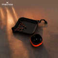Small black tray with coffee beans and a red and Macnoa MacX mistFlow Electric Coffee Atomizer on a textured surface, featuring the brand 'macnoa'.